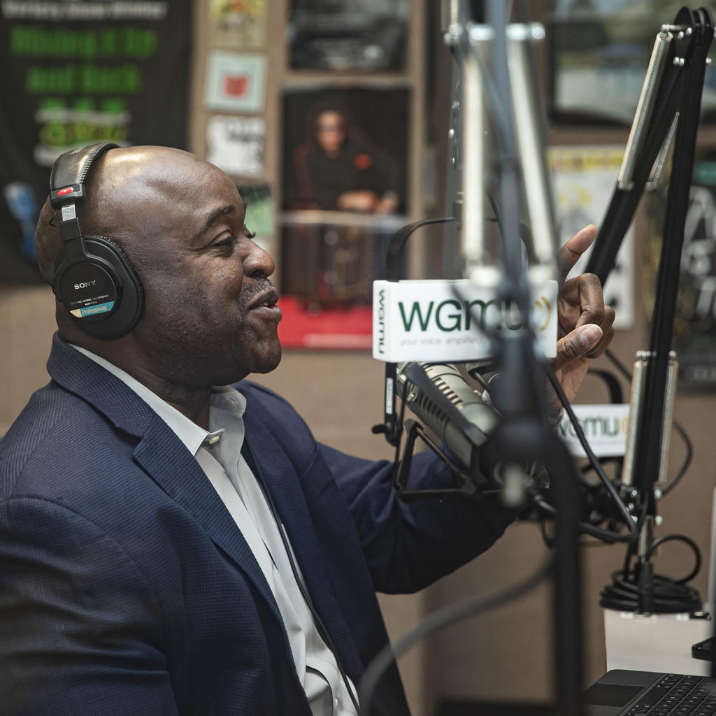 President of 番茄视频, Gregory Washington, speaking into a mic in a recording studio, recording his podcast Access to Excellence