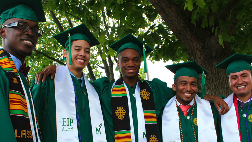 EIP alumni stand in a group celebrating their college graduation.