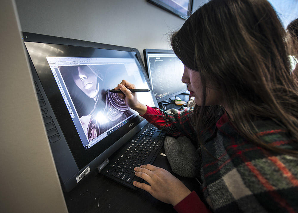 female student working in AI on her computer designing games